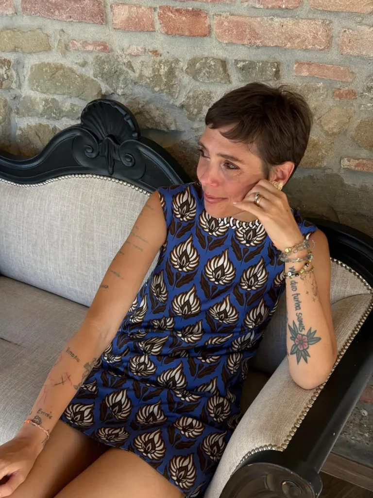 Gaia seduta con un vestito blu a fiori bianchi